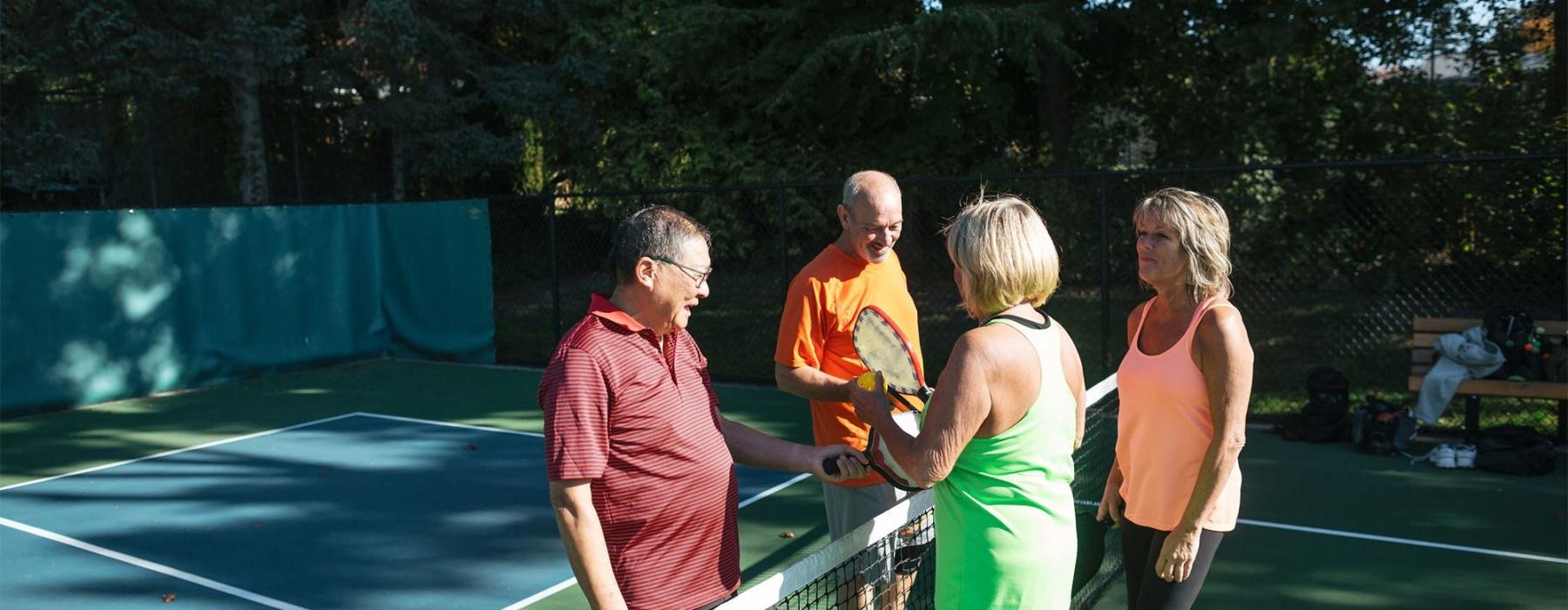 a group of people standing on a Pickleball court