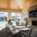 a patio with a fireplace and chairs next to a pool